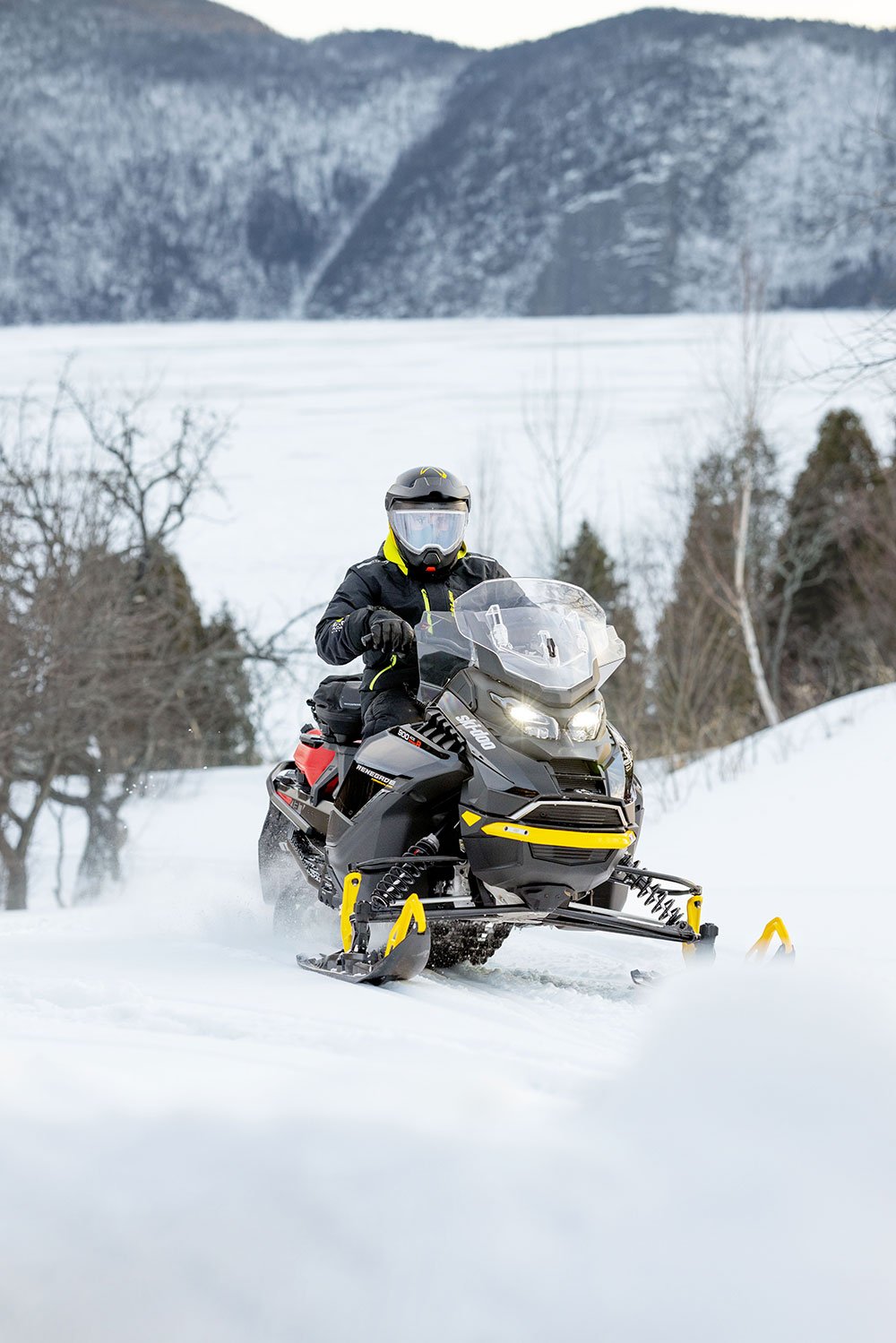 A Person Riding A Snowmobile On A Snowy Trail